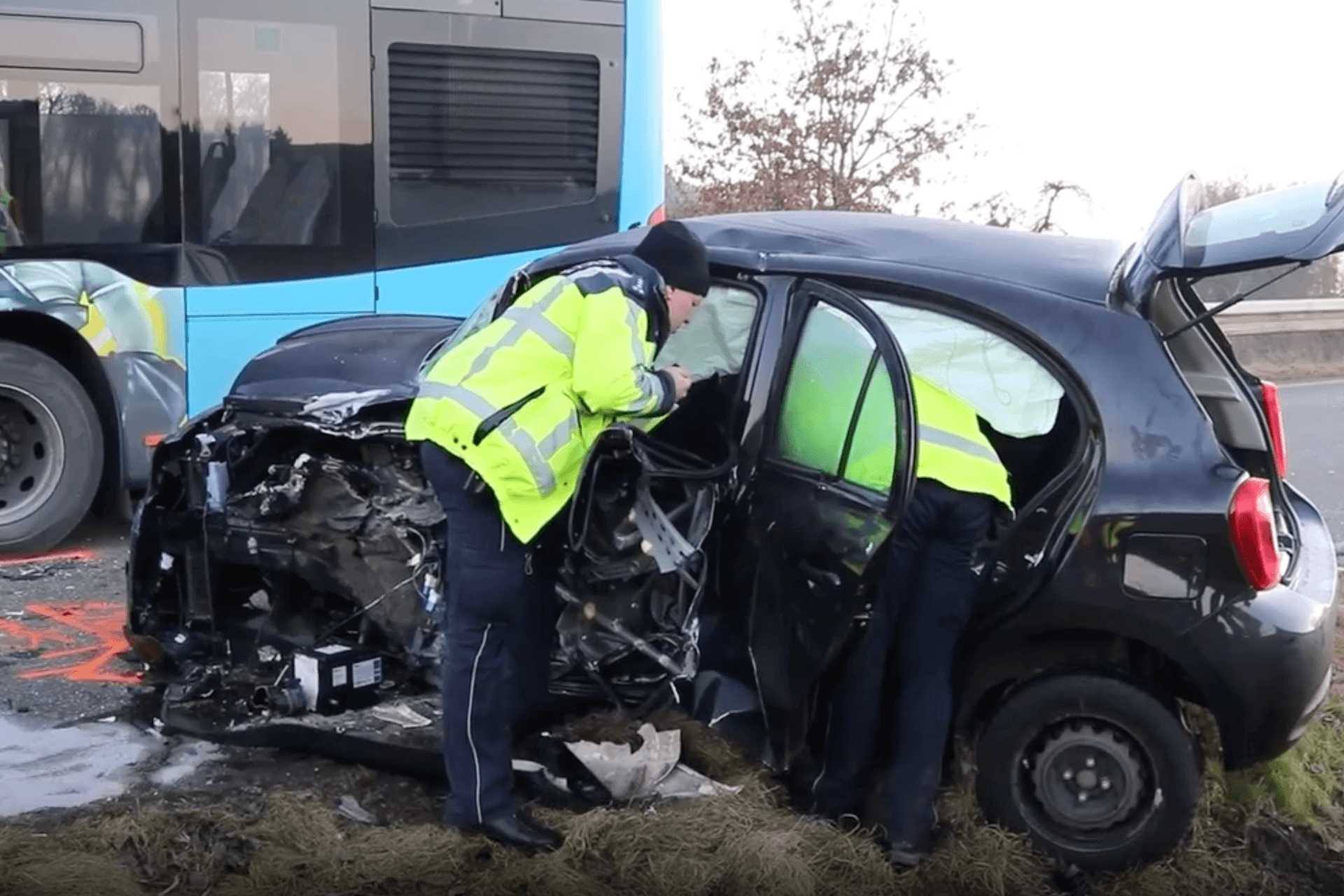 Einsatzkräfte untersuchen ein Auto mit einer zerstörten Front.