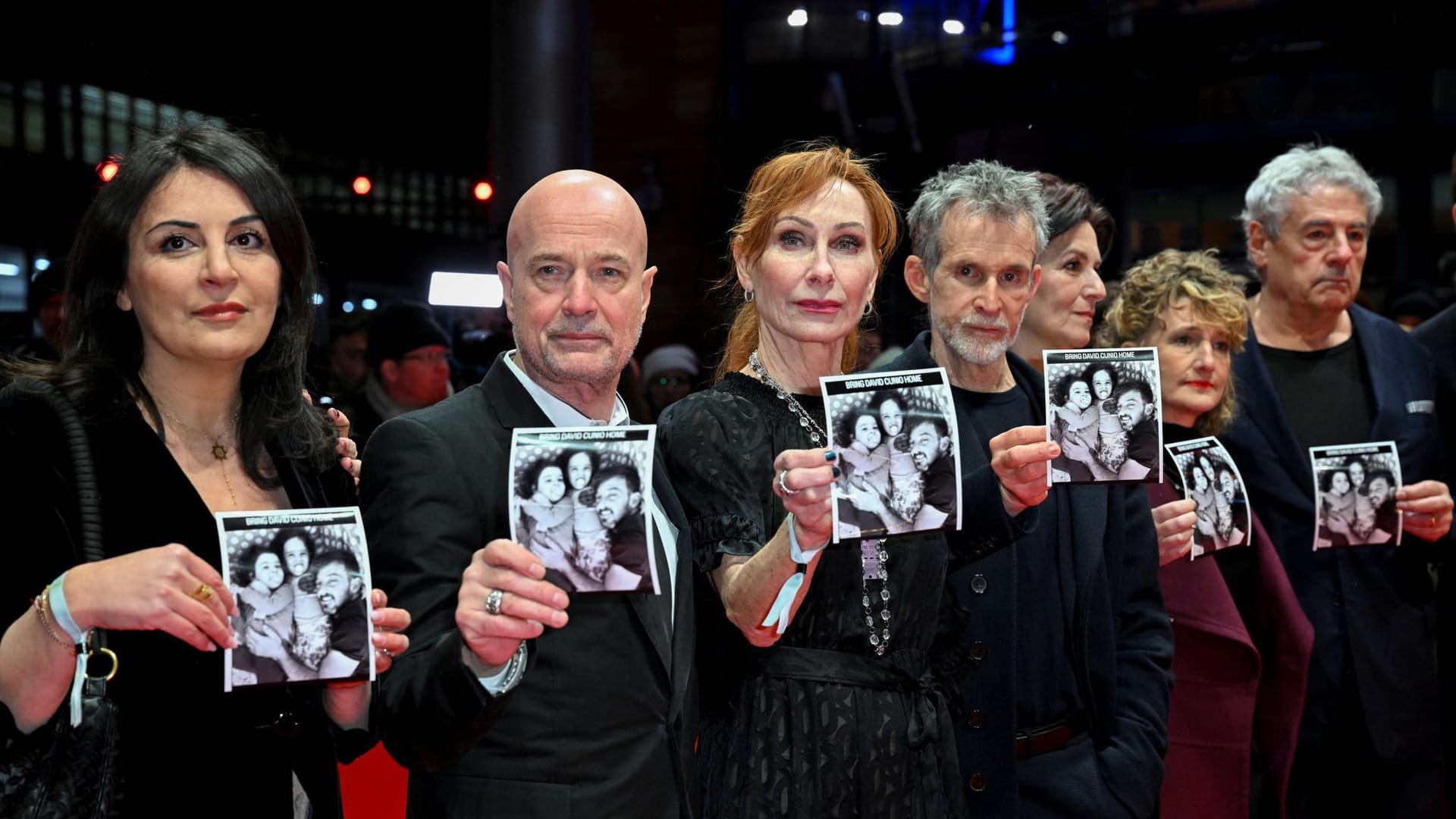 Duzen Tekkal, Christian Berkel, Andrea Sawatzki, Ulrich Matthes und Berlinale-Chefin Tricia Tuttle (v.l.n.r.) zeigen ein Foto der israelischen Hamas-Geisel David Cunio.