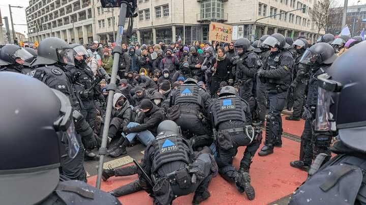 Polizisten räumen eine Blockade durch Gegendemonstranten in Dresden. Dabei sollen auch Tritte und Pfefferspray eingesetzt worden sein.