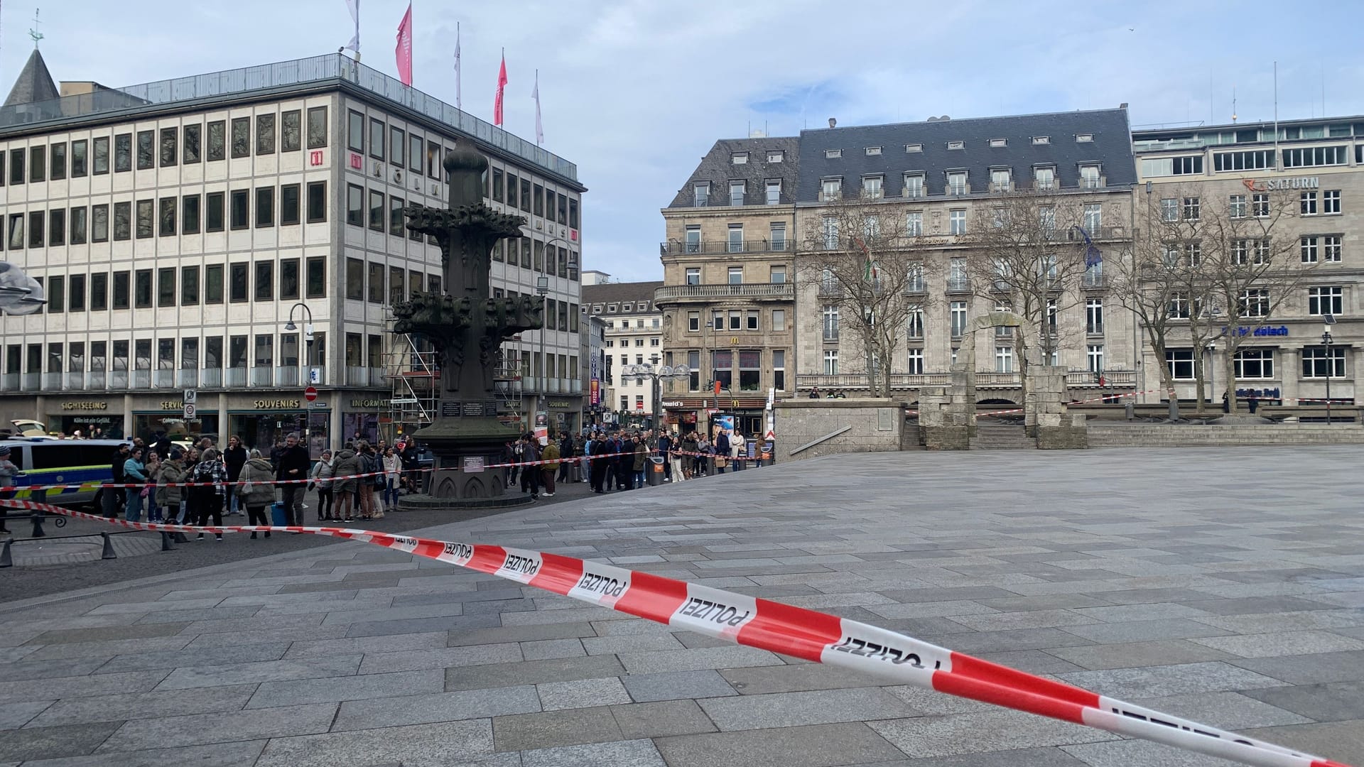 Die Absperrung an der Kölner Domplatte lockt zahlreiche Schaulustige an. Die Absperrung an der Kölner Domplatte lockt zahlreiche Schaulustige an.