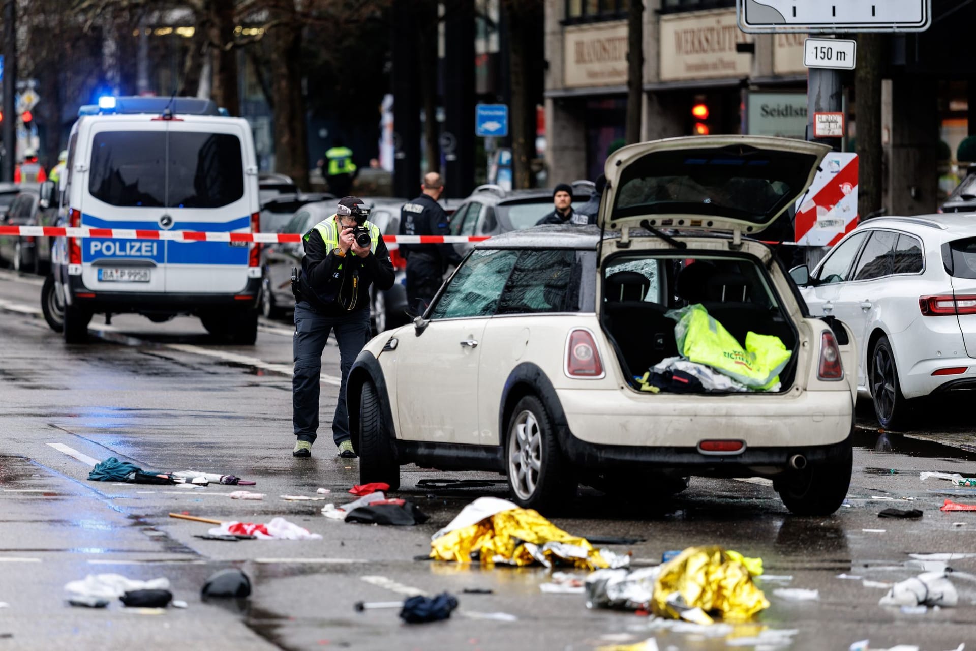 Ein Polizist fotografiert ein Auto am Einsatzort. In der Münchner Innenstadt ist ein Fahrzeug in eine Menschengruppe gefahren.