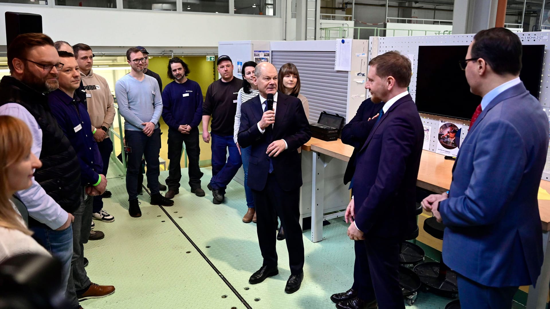 Olaf Scholz (mit Mikrofon) und Sachsens Ministerpräsident Michael Kretschmer in einer Werkhalle der Alstom GmbH in Görlitz.