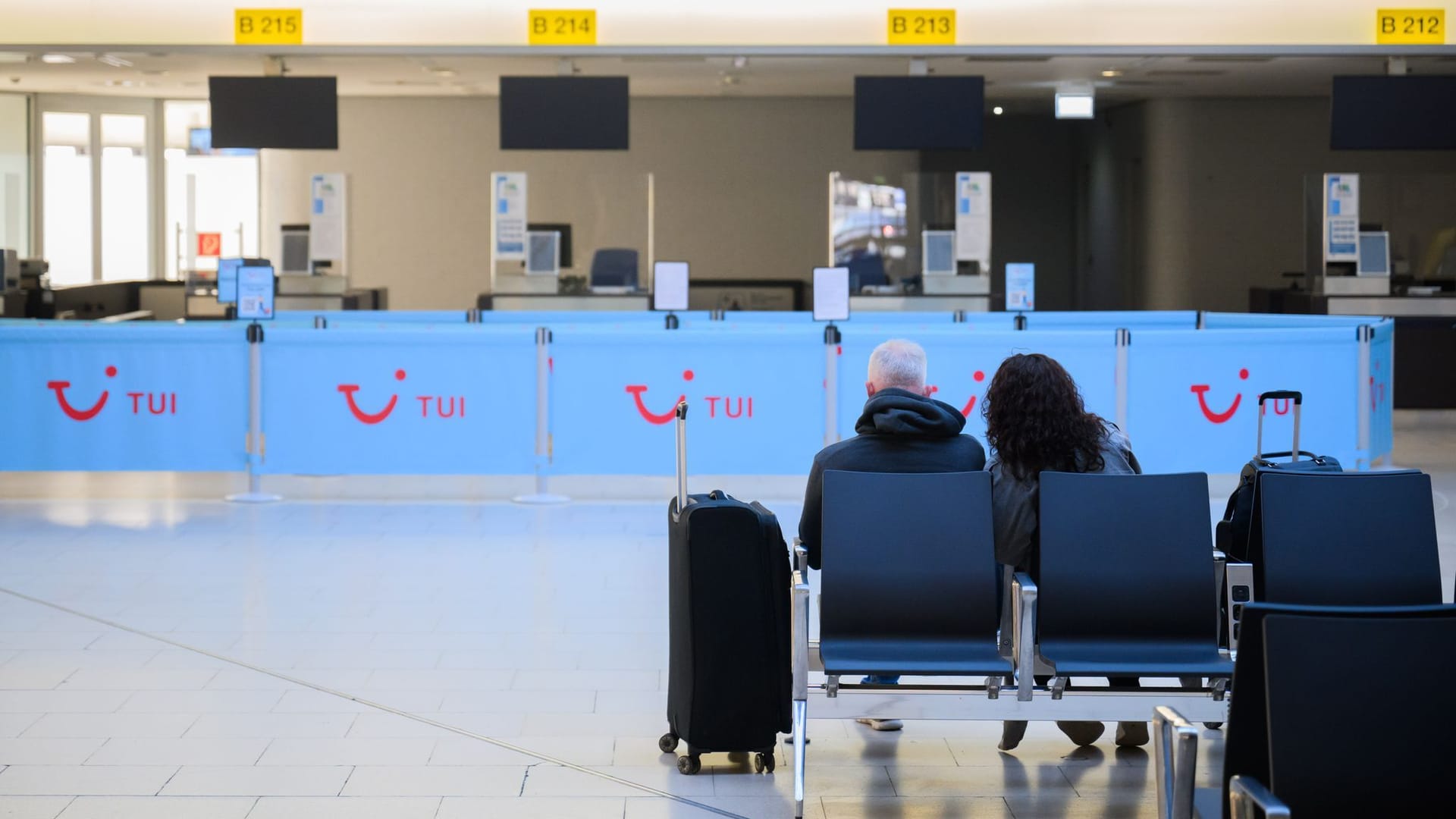 Ein Paar sitzt mit Koffern am Flughafen Hannover: Die Gewerkschaft Verdi hat die Beschäftigten des öffentlichen Dienstes zum Streik aufgerufen.