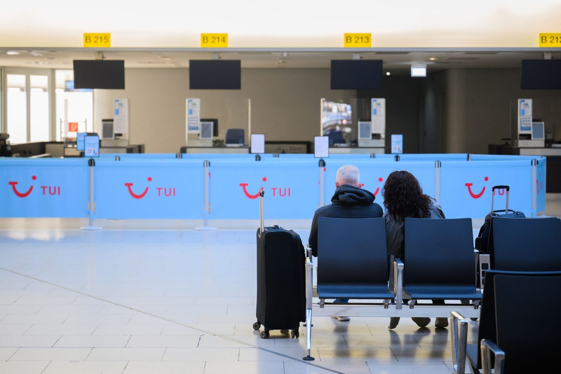 Ein Paar sitzt mit Koffern am Flughafen Hannover: Die Gewerkschaft Verdi hat die Beschäftigten des öffentlichen Dienstes zum Streik aufgerufen.