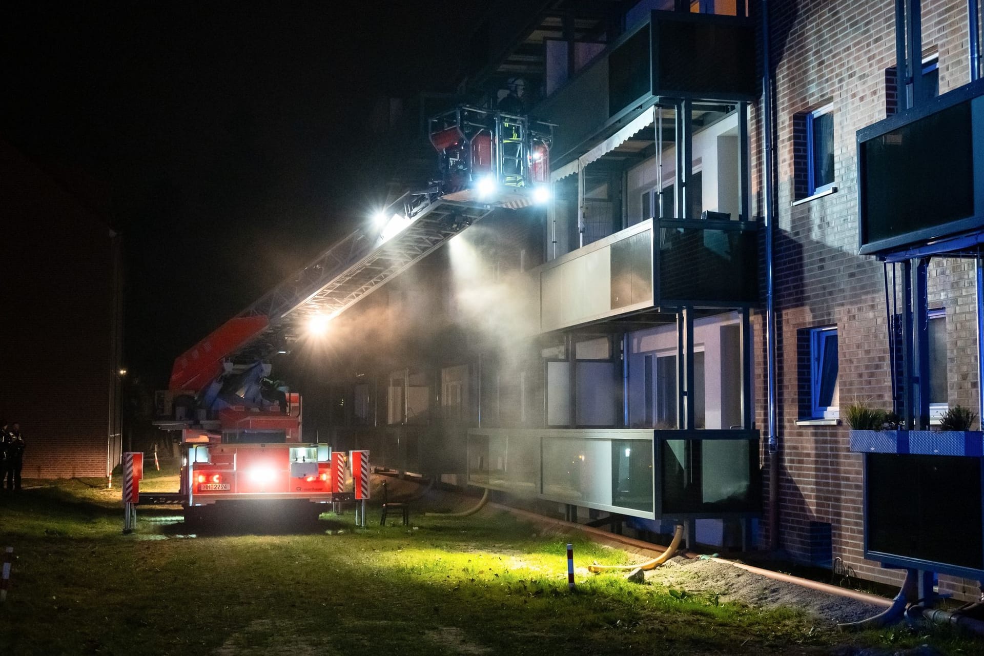 Ein Drehleiterfahrzeug steht vor einem Hamburger Mehrfamilienhaus: Im Keller brannte es.