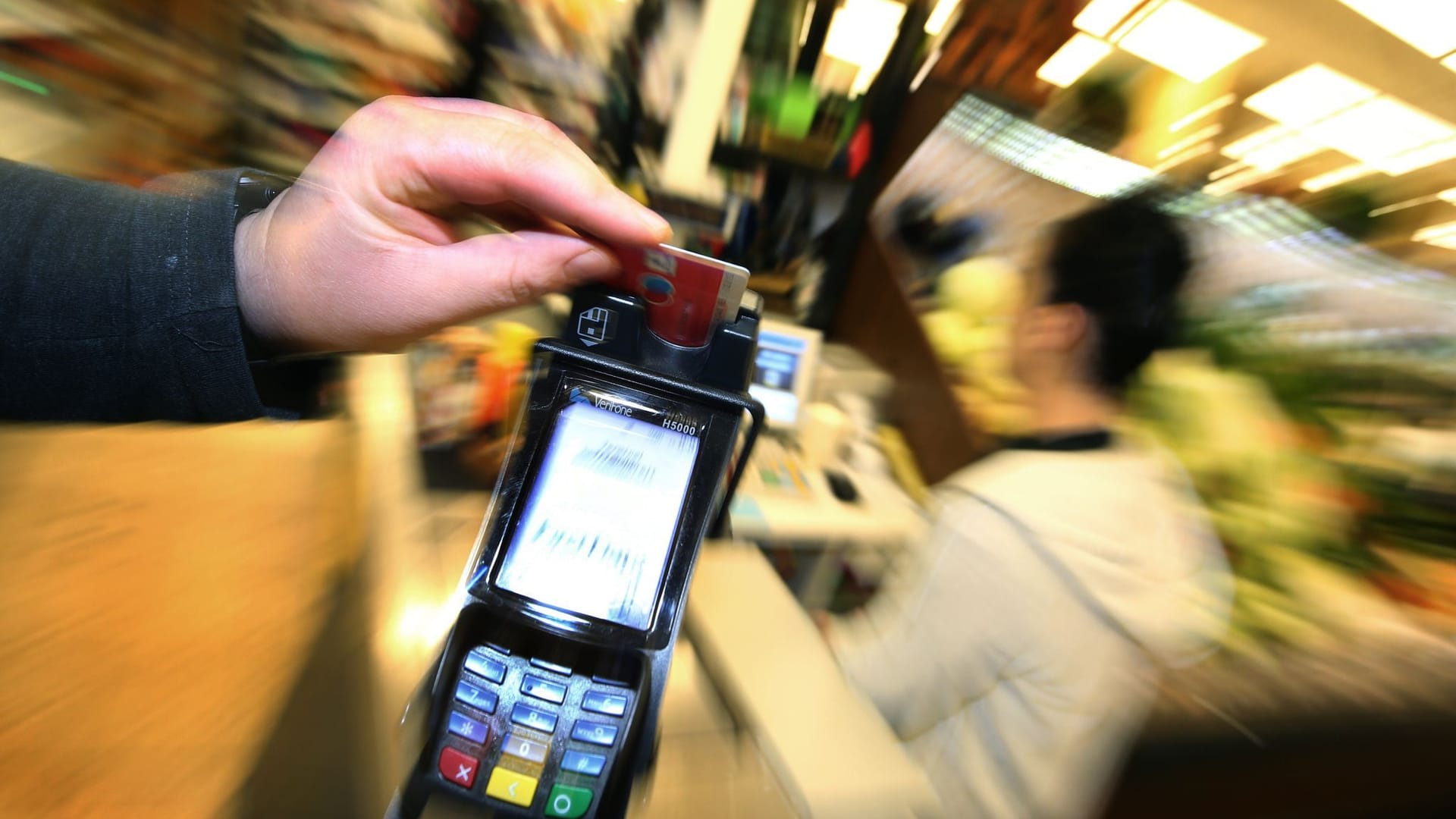 Mann bezahlt mit EC-Karte im Supermarkt