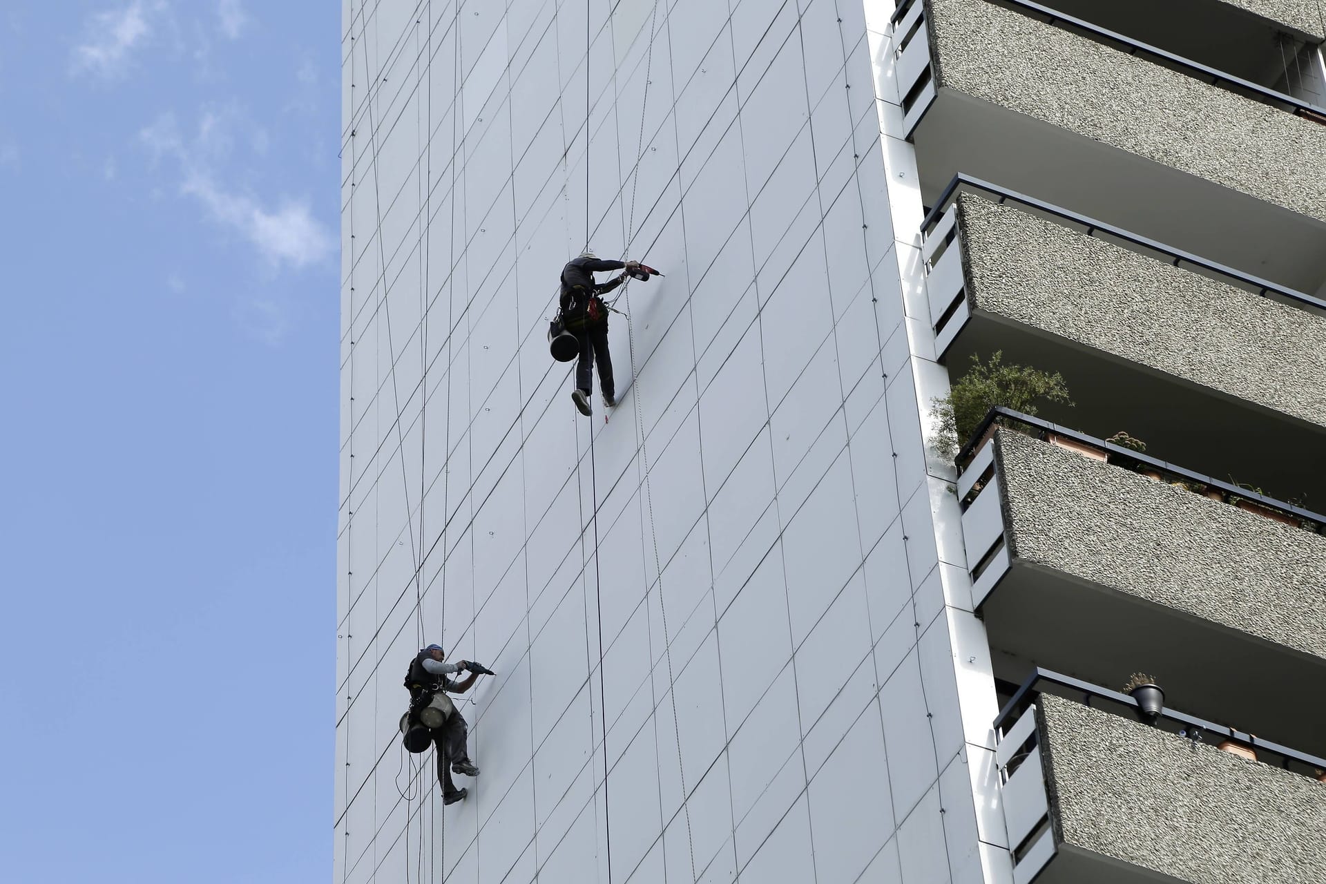 Industriekletterer arbeiten an der Fassade einen Hochhauses (Symbolbild): Warum sich Mann nachts abseilte, ist unklar.