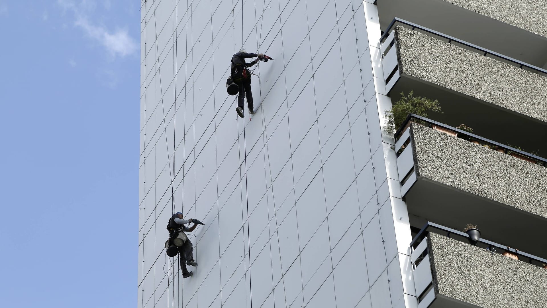 Industriekletterer arbeiten an der Fassade einen Hochhauses (Symbolbild): Warum sich Mann nachts abseilte, ist unklar.