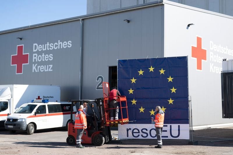 Mitarbeiter des Deutschen Roten Kreuzes (DRK) befestigen vor dem DRK-Logistikzentrum eine Plane mit der Aufschrift "rescEU": Es sei bereits die 16. Hilfslieferung in den Gazastreifen.