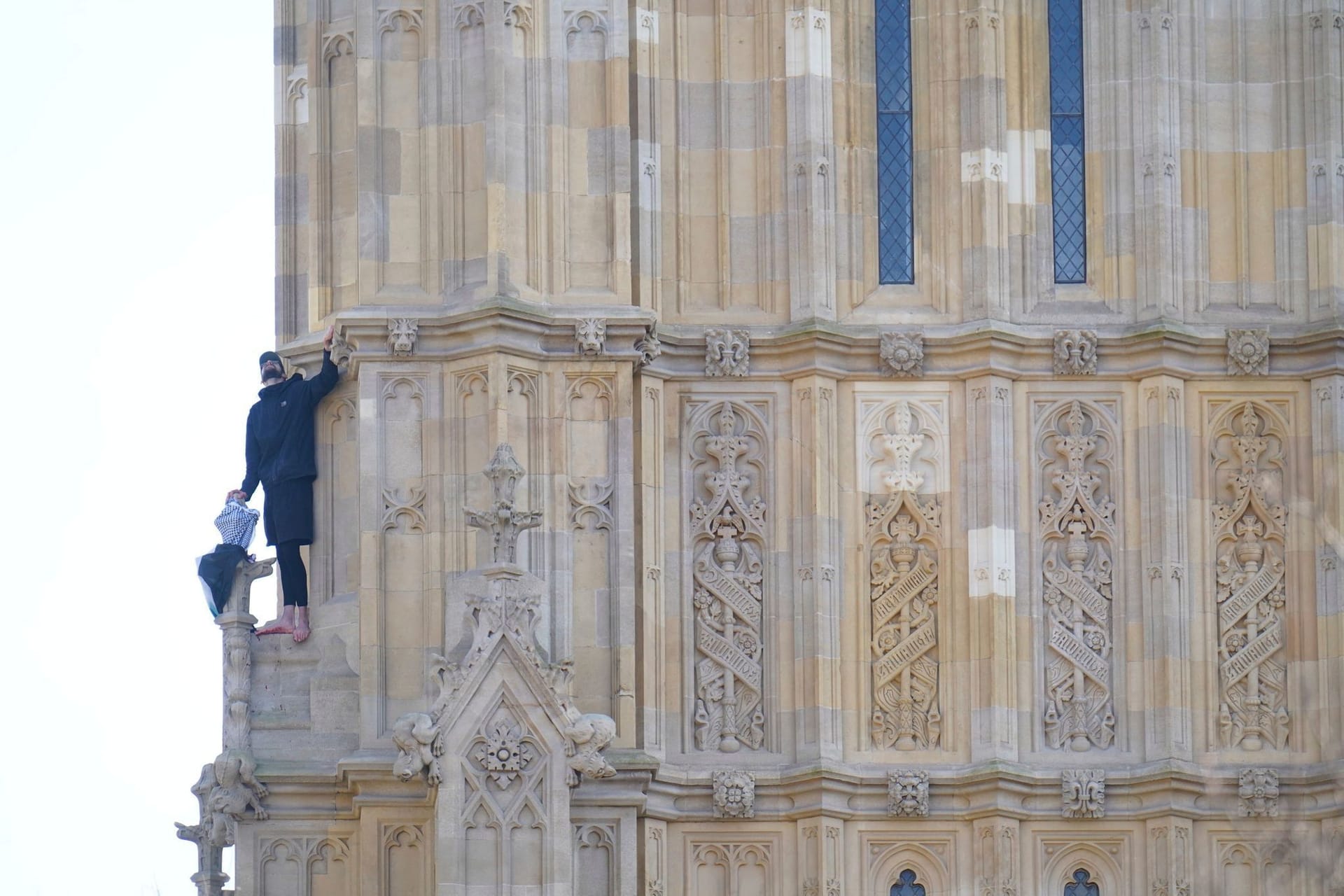 Ein Mann klettert barfuß auf den Big Ben.