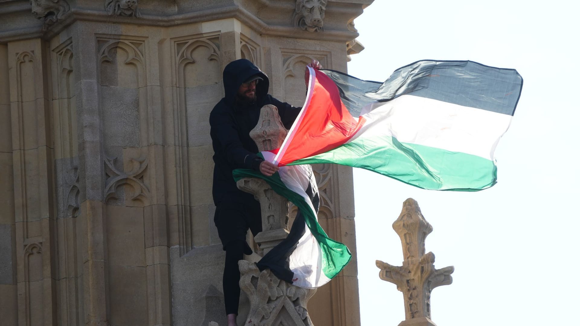 Ein Mann hält eine palästinensische Flagge in der Hand, nachdem er am Big Ben auf den Elizabeth Tower geklettert ist.