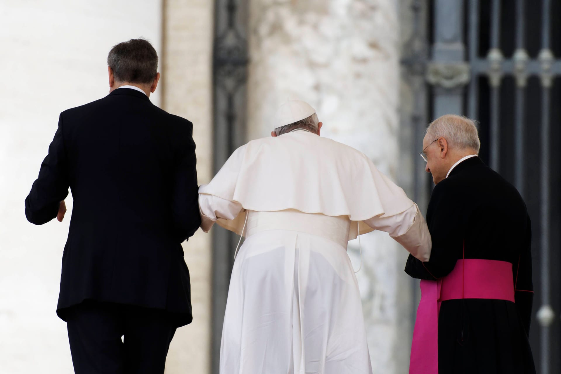 Papst Franziskus wird von zwei Personen gestützt: TikToker versuchen, Beweise für Verschwörungstheorien über seinen Gesundheitszustand zu finden.