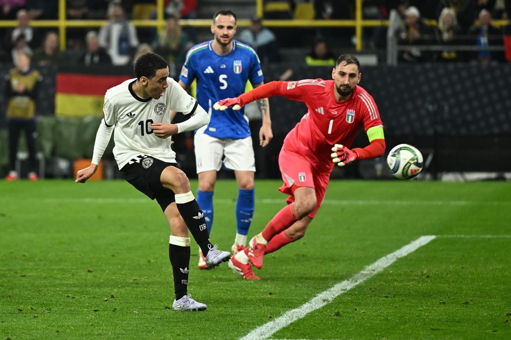 Zu soät: Italiens Torwart Donnarumma (r.) kann dem Schuss von Musiala nur noch hinterherschauen.