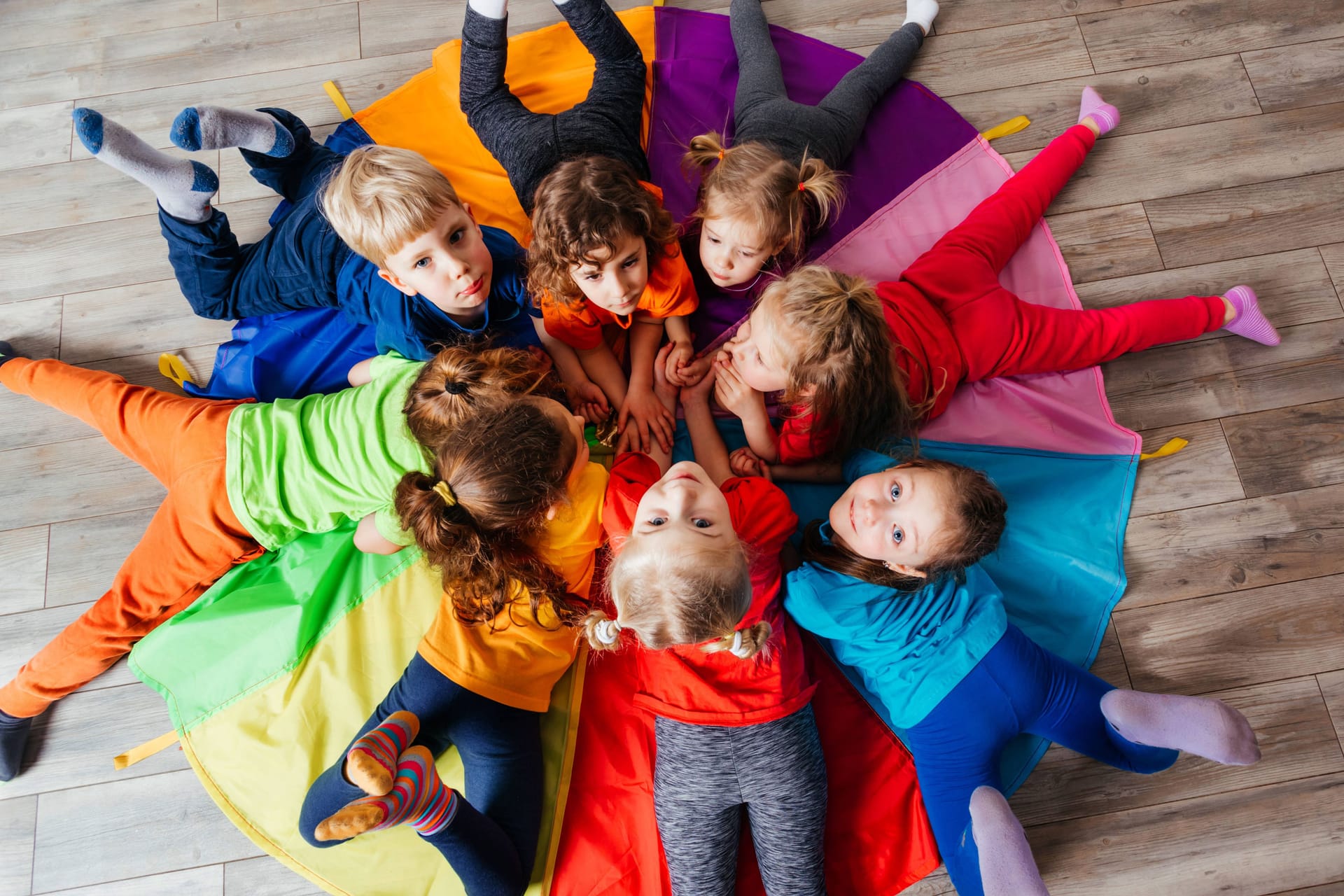 Kinder spielen auf dem Boden (Symbolbild): Die Betreuung in Bremer Kitas soll in Zukunft flexibler gehandhabt werden.