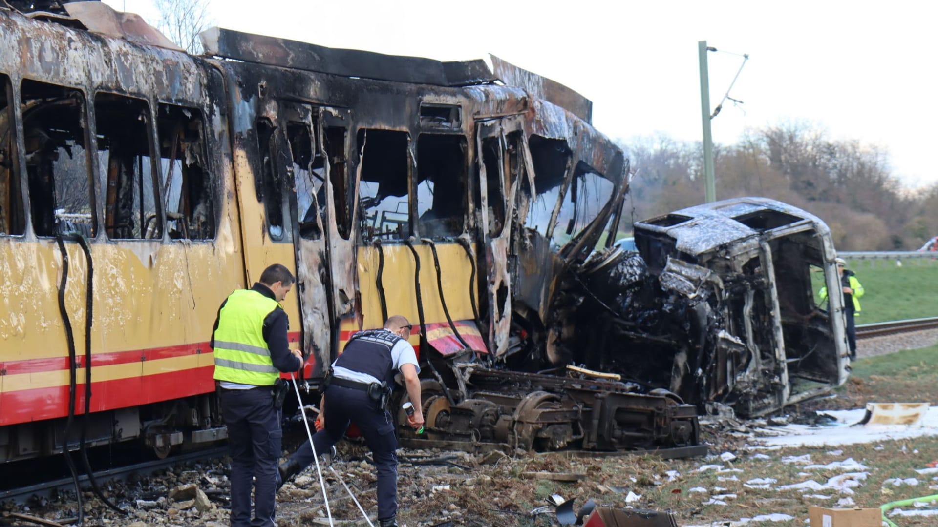 Tanklaster und Stadtbahn nach dem Brand: Beamte nehmen die Unfallstelle in Augenschein.