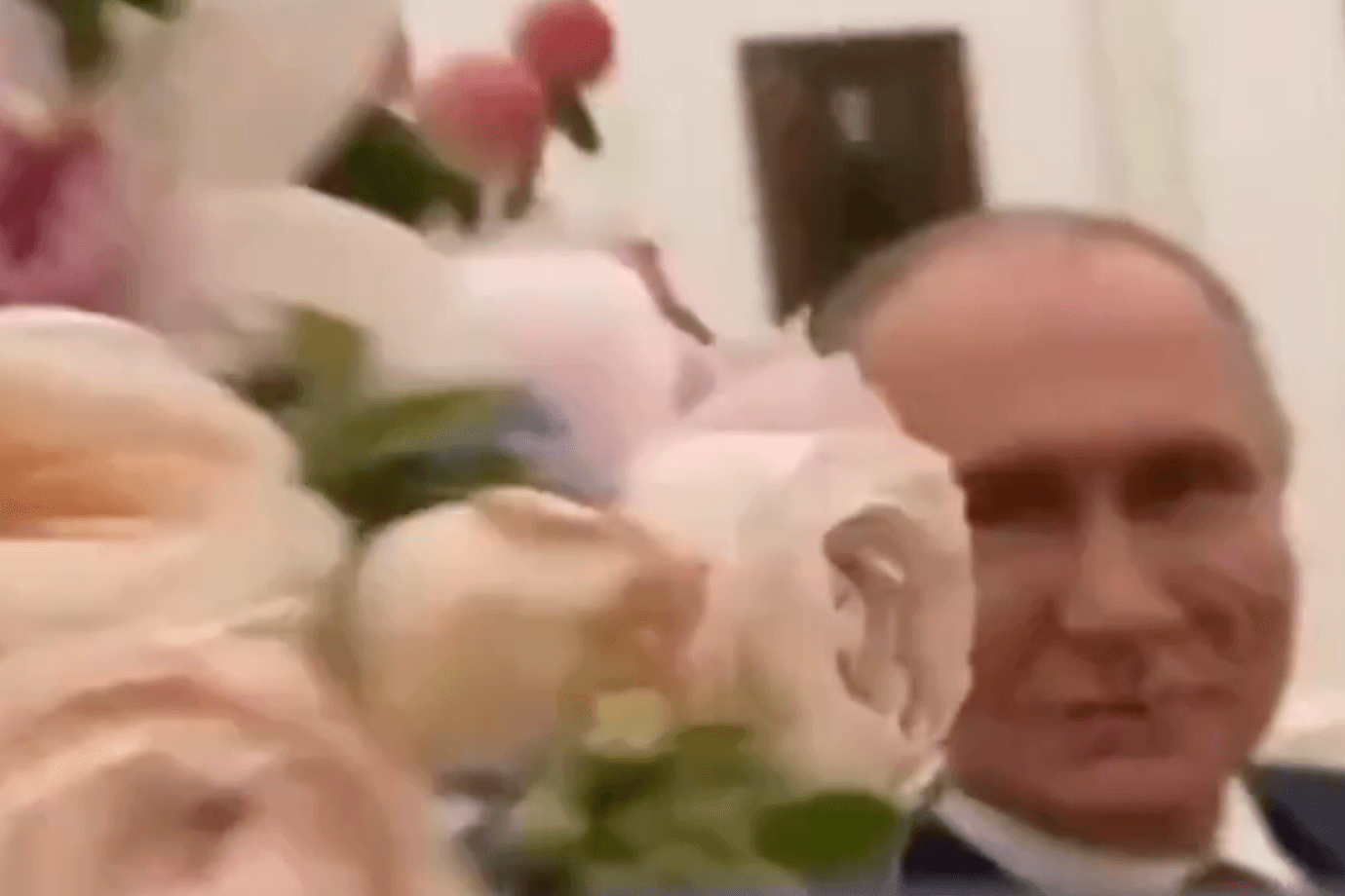 Frauentag: Putin hält Blumen in die Kamera.