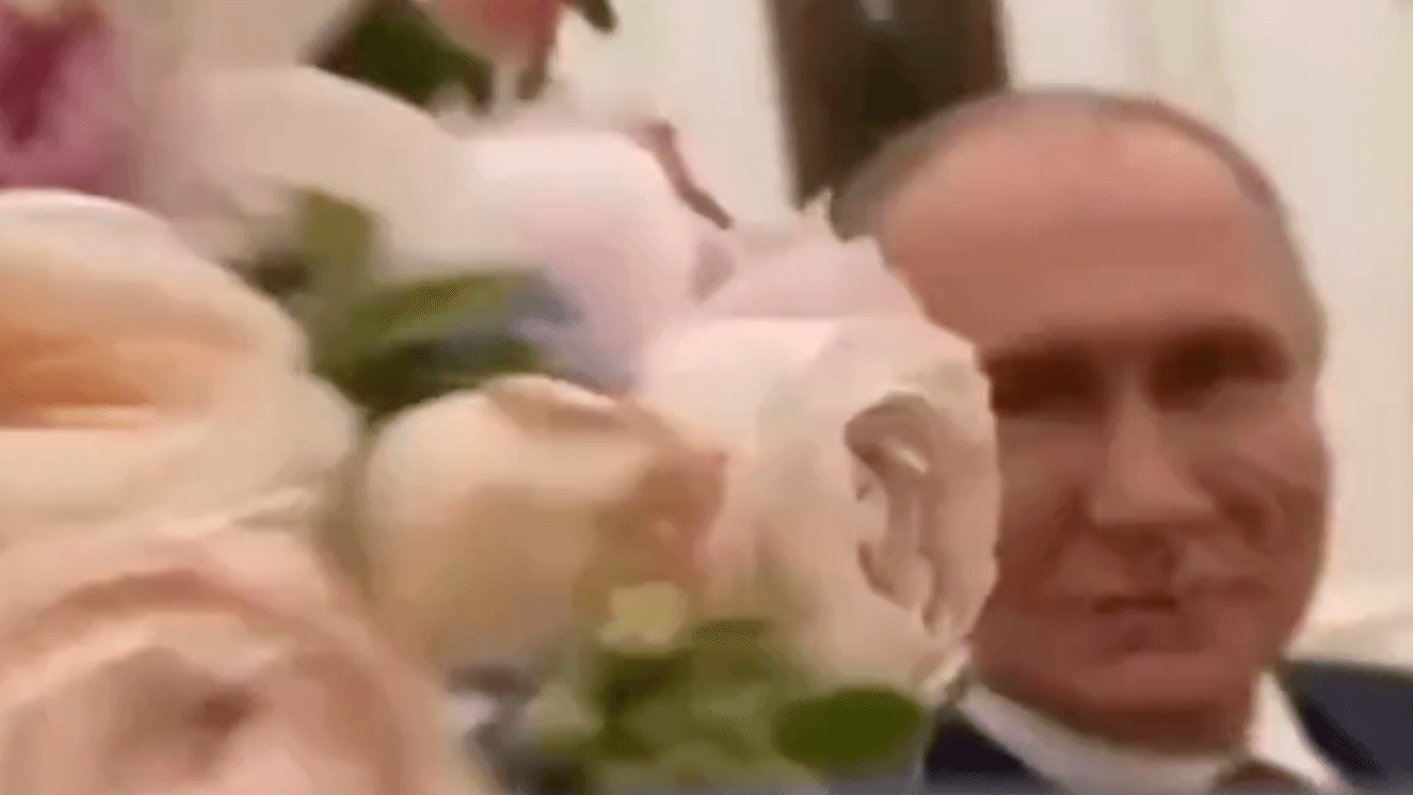 Frauentag: Putin hält Blumen in die Kamera.