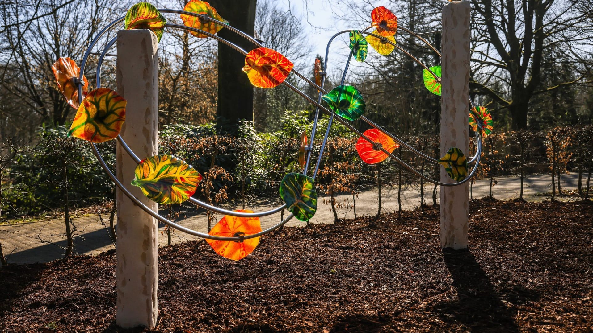 Zum zehnten Jahrestag haben Eltern in Haltern eine Skulptur in Auftrag gegeben. 18 gläserne Blätter funkeln bunt im Licht.