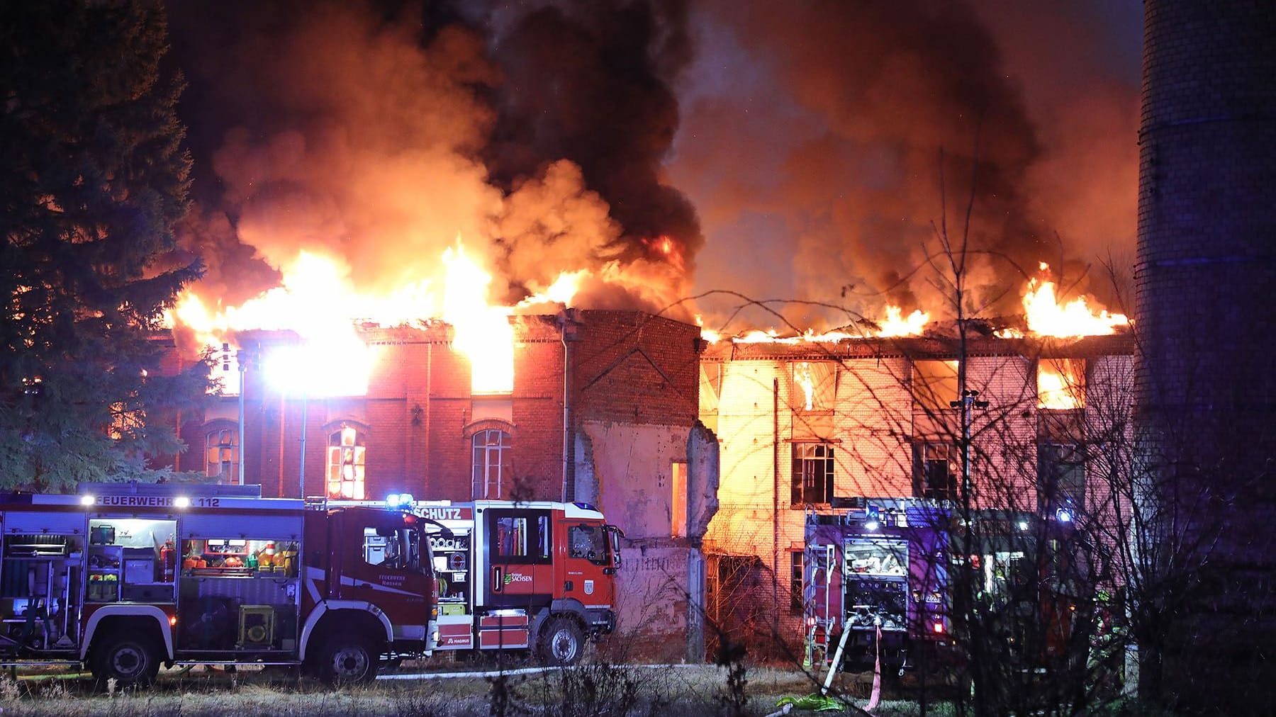 Feuerwehrfahrzeuge und Rettungskräfte vor einem brennenden Gebäude: Bei dem Brand in der ehemaligen Puppenfabrik wurde niemand verletzt.