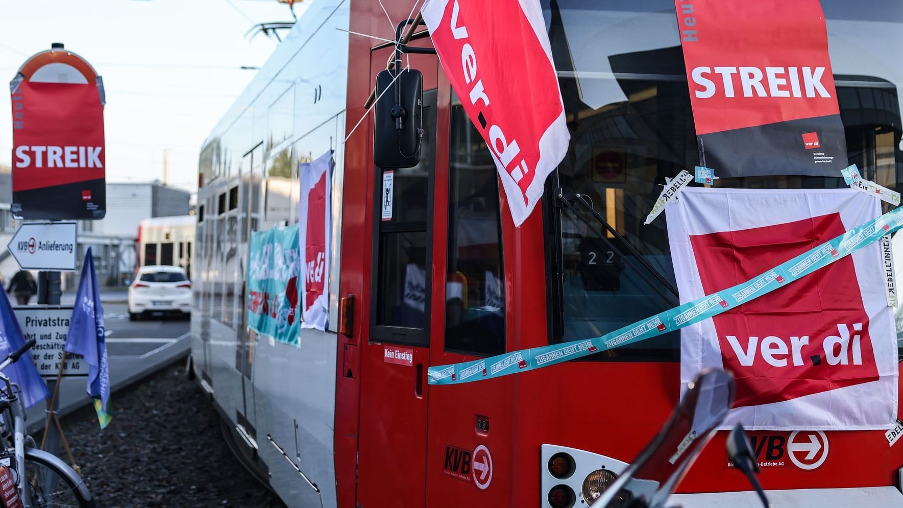 Köln (Archivbild): Eine mit Streik-Plakaten beklebte Straßenbahn der Kölner Verkehrs-Betriebe (KVB) steht vor dem Bahndepot.