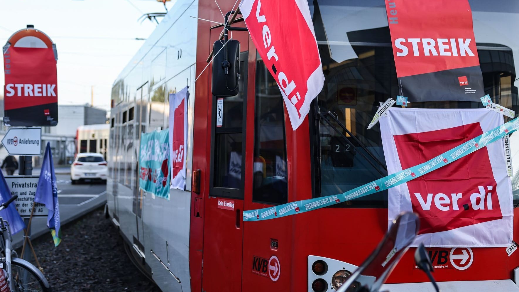 Köln (Archivbild): Eine mit Streik-Plakaten beklebte Straßenbahn der Kölner Verkehrs-Betriebe (KVB) steht vor dem Bahndepot.