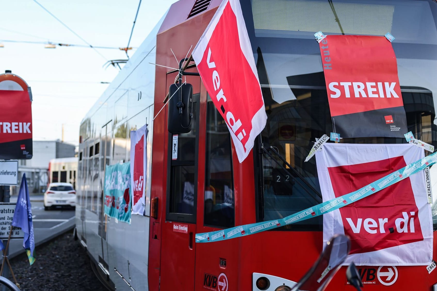 Köln (Archivbild): Eine mit Streik-Plakaten beklebte Straßenbahn der Kölner Verkehrs-Betriebe (KVB) steht vor dem Bahndepot.