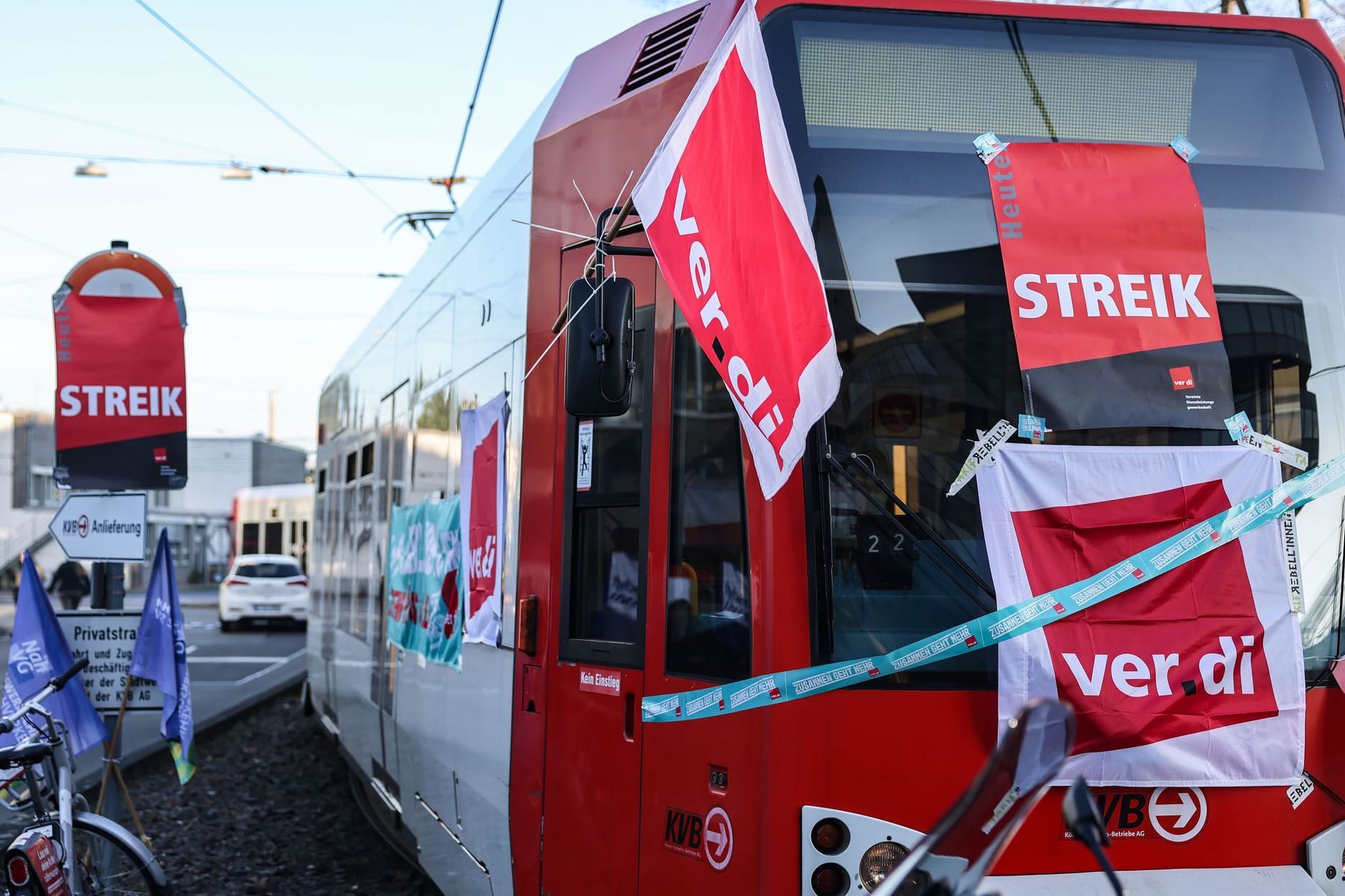 Köln (Archivbild): Eine mit Streik-Plakaten beklebte Straßenbahn der Kölner Verkehrs-Betriebe (KVB) steht vor dem Bahndepot.