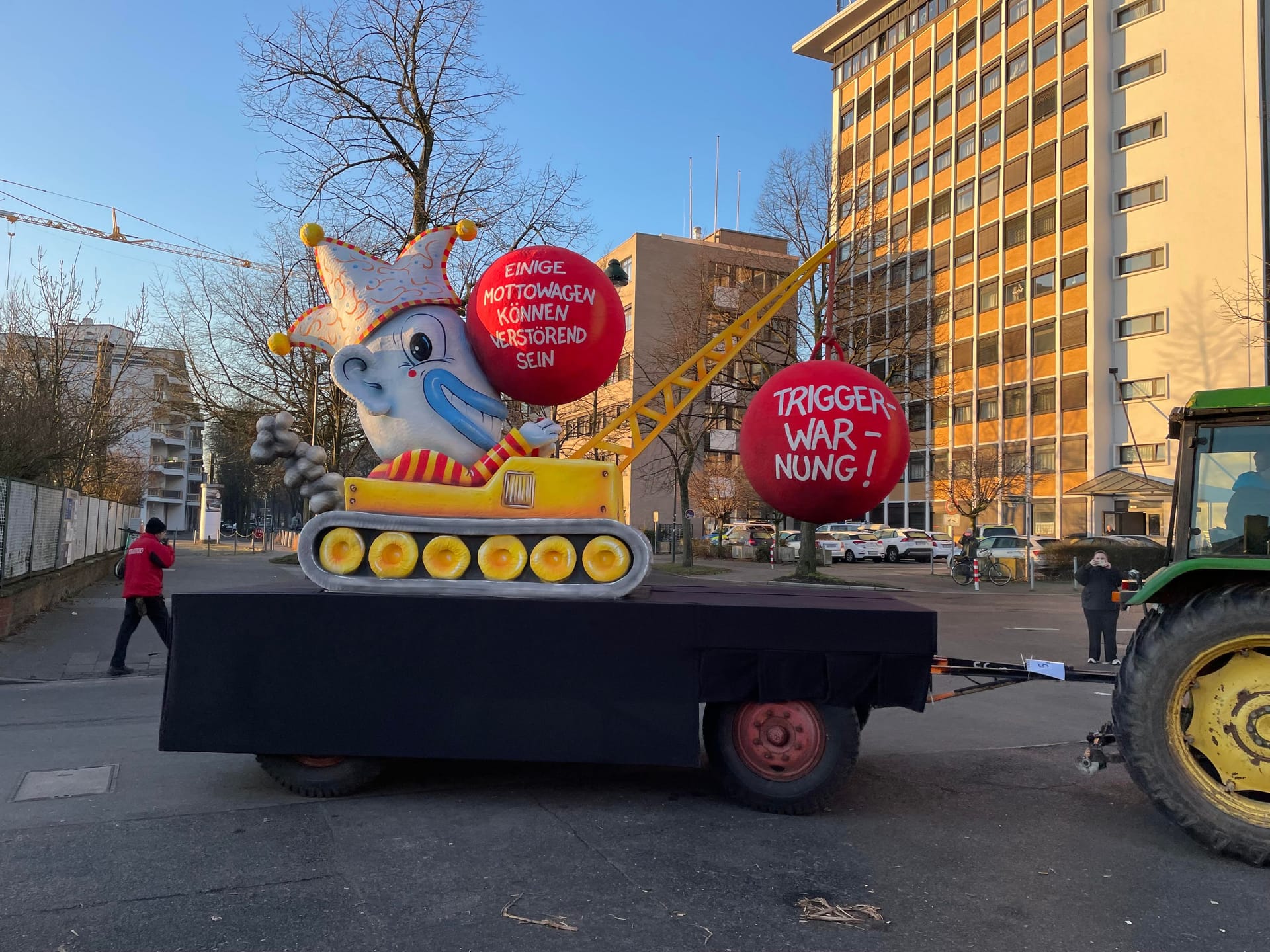 Eine Abrissbirne warnt vor den pikanten Mottowagen. "Triggerwarnung" ist auf der roten Kugel zu lesen. Auf dem Fahrzeug selbst ist eine Narrenfigur mit riesiger Nase zu sehen. Auf dem übergroßen Riechorgan ist zu lesen: "Einige Mottowagen können verstörend sein".