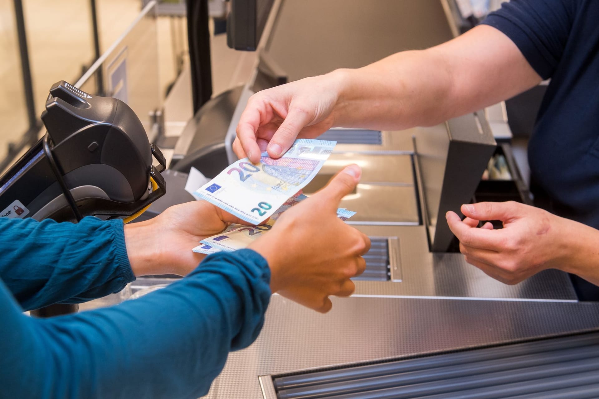 Frau hebt Geld im Supermarkt ab