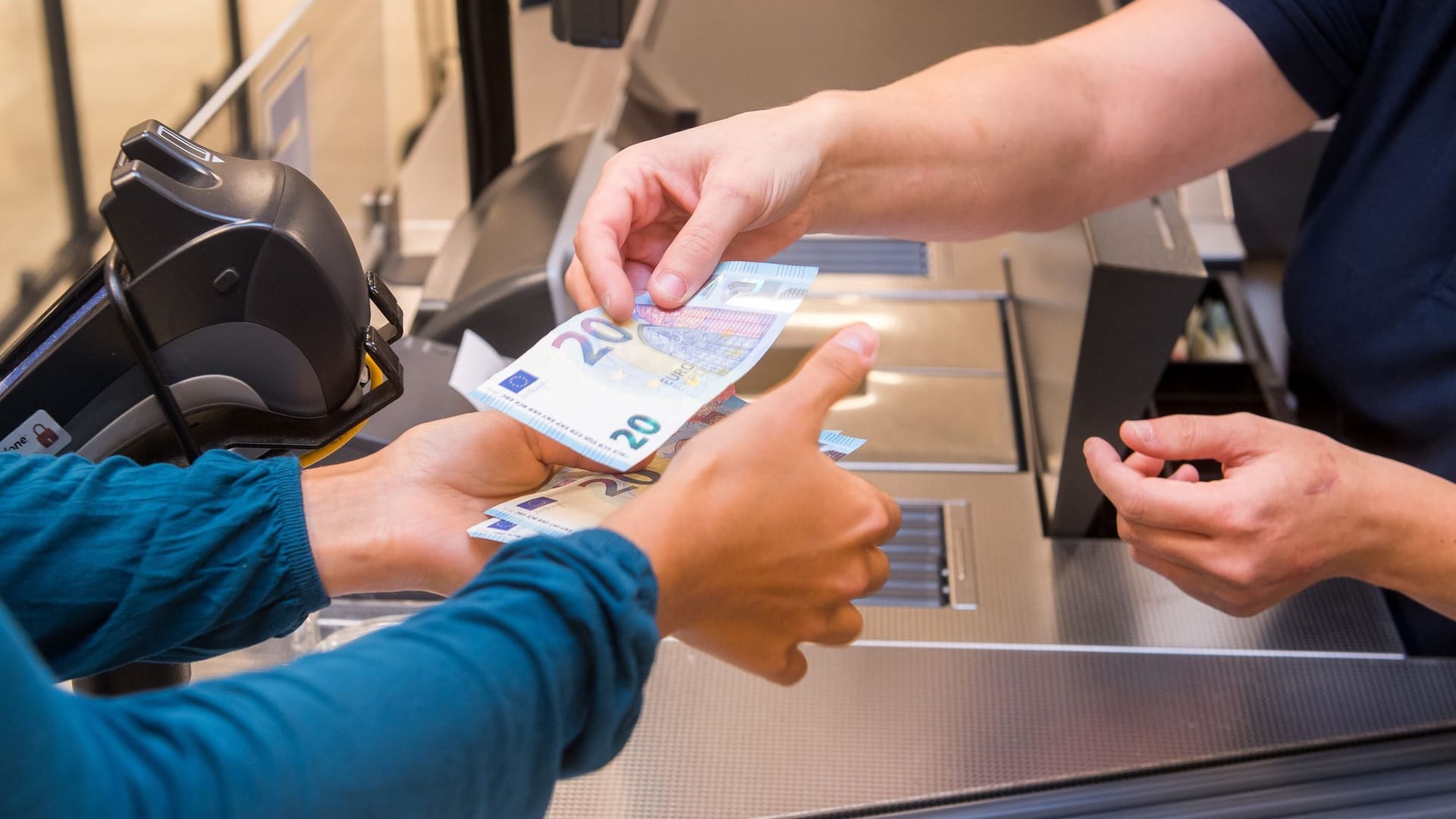 Frau hebt Geld im Supermarkt ab