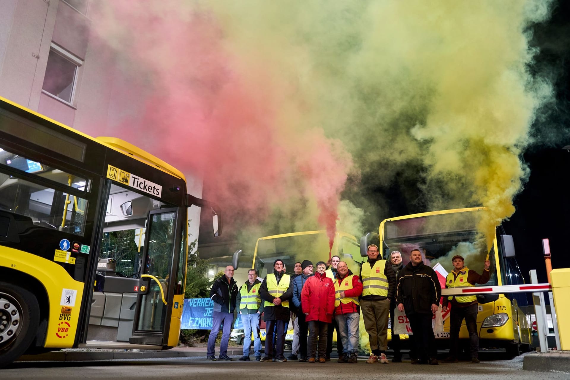 Streikende BVG-Mitarbeiter stehen mit qualmenden Leuchtfackeln in den Händen an der Zufahrt zum Betriebshof in der Siegfriedstraße. In der Nacht hat der zweitägige Warnstreik im Berliner Nahverkehr begonnen.