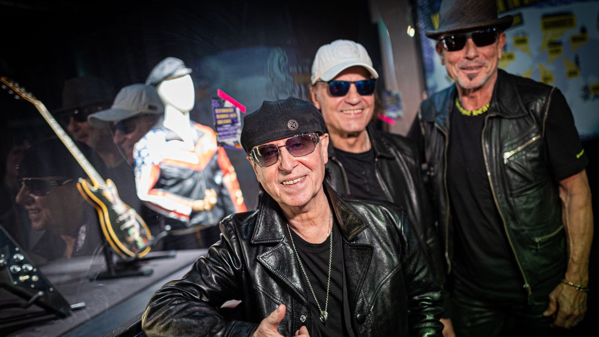 Klaus Meine, Matthias Jabs und Rudolf Schenker stehen vor den Band-Exponaten.