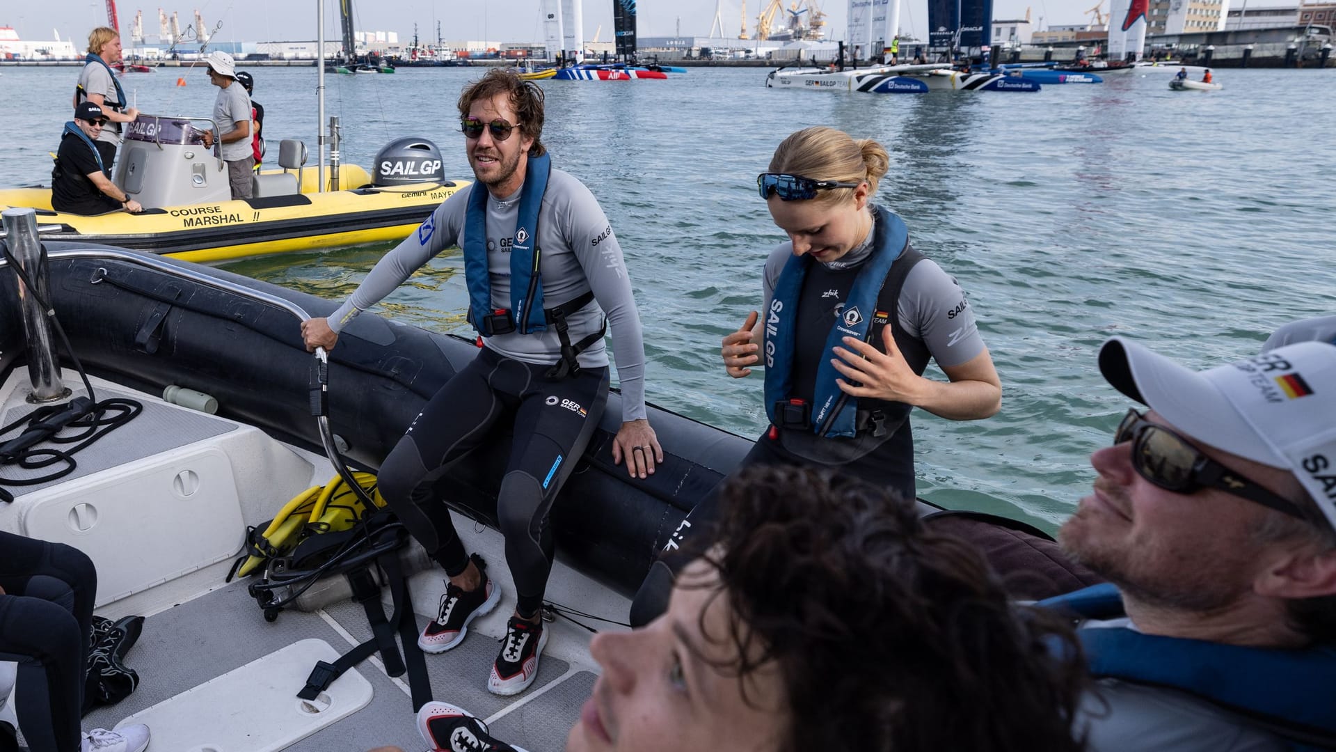 Sebastian Vettel (hi.) ist Mitbesitzer des deutschen SailGP-Teams und besucht die Crew um Anna Barth (r. daneben) auch bei Rennen wie 2023 in Cádiz.