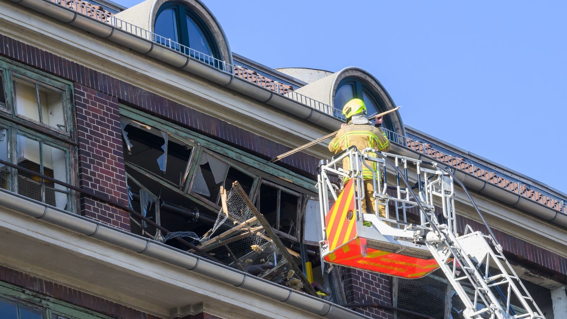 Hannover: Feuerwehrkräfte sichern von einer Drehleiter aus die zerstörte Fassade am Continental-Gebäude.