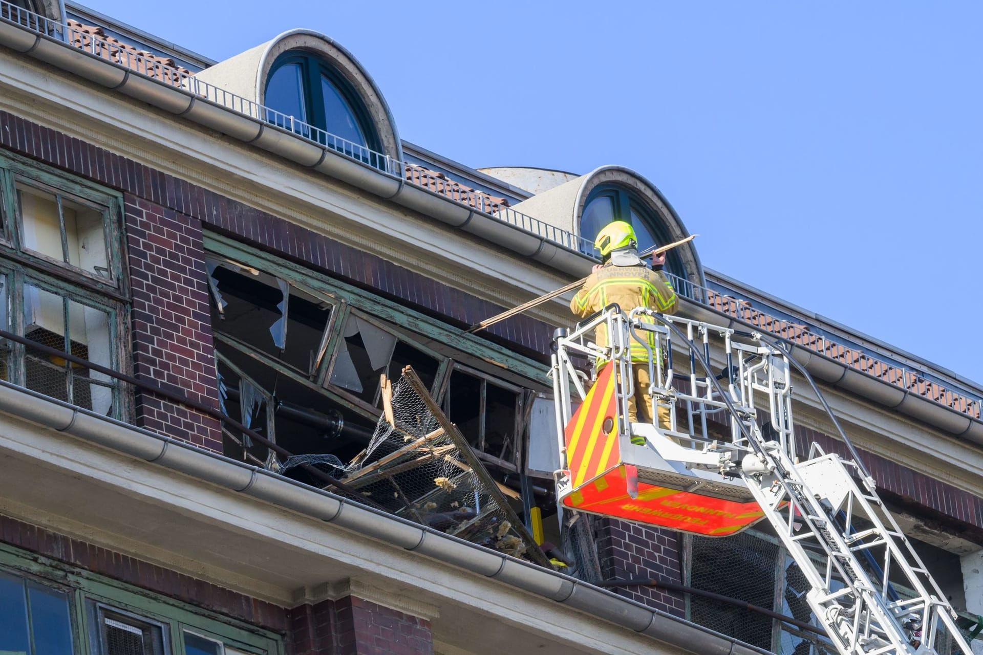 Hannover: Feuerwehrkräfte sichern von einer Drehleiter aus die zerstörte Fassade am Continental-Gebäude.