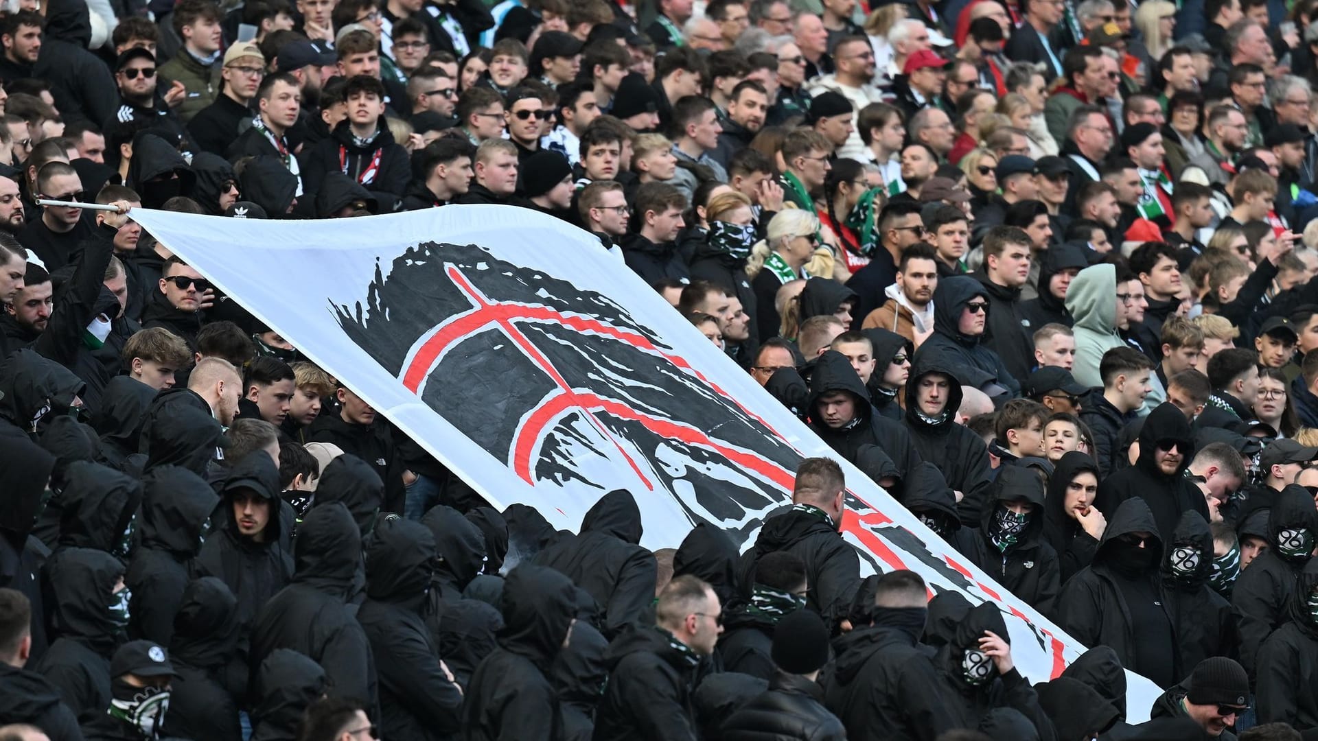 Ein Banner mit Fadenkreuz und einem Abbild von Daniela Behrens: Die Innenministerin wird von den Fans hart angegangen.