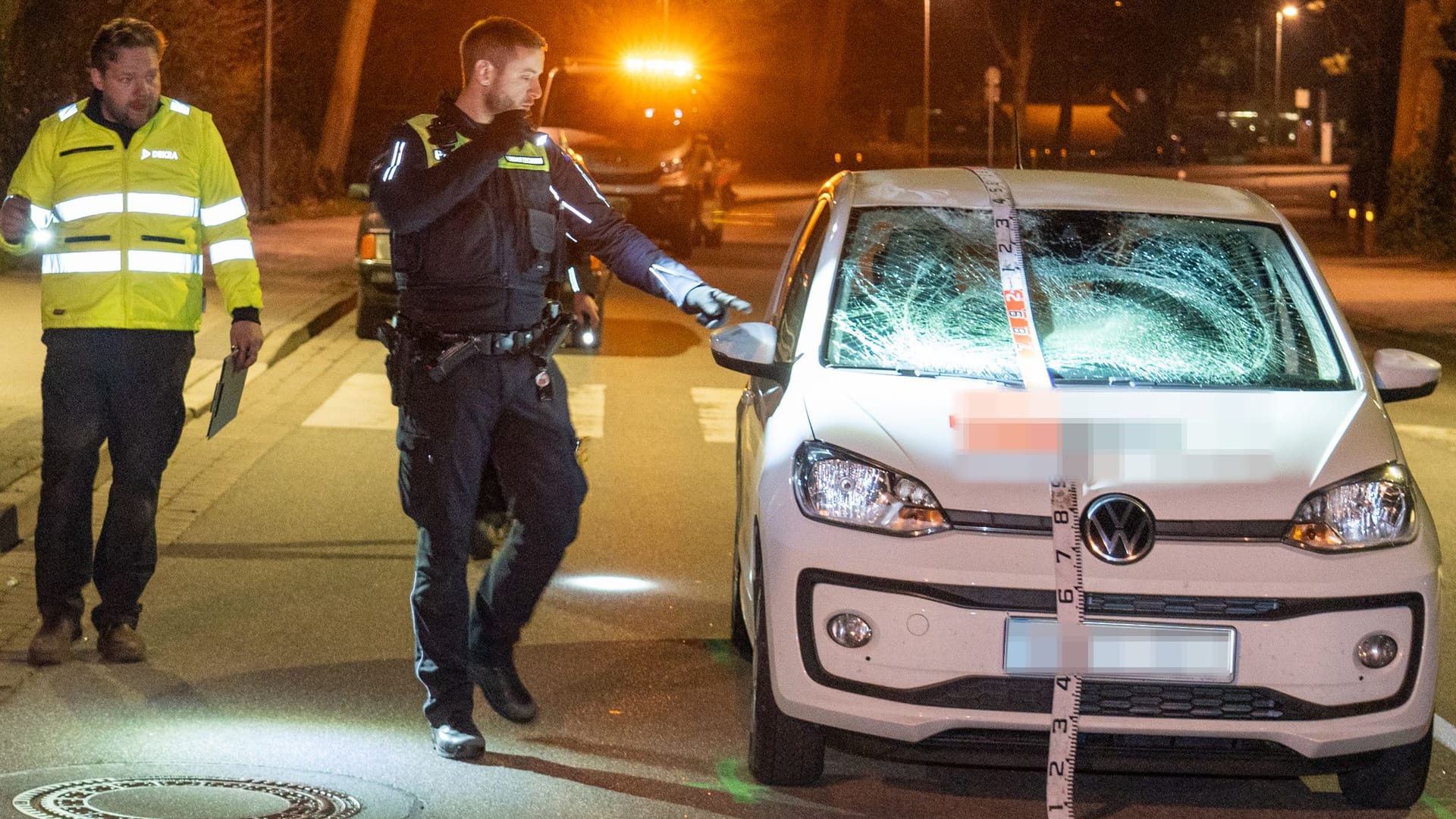 Polizisten stehen an einem Unfallauto: In Winsen (Luhe) wurde Dienstagabend ein Fußgänger schwer verletzt.