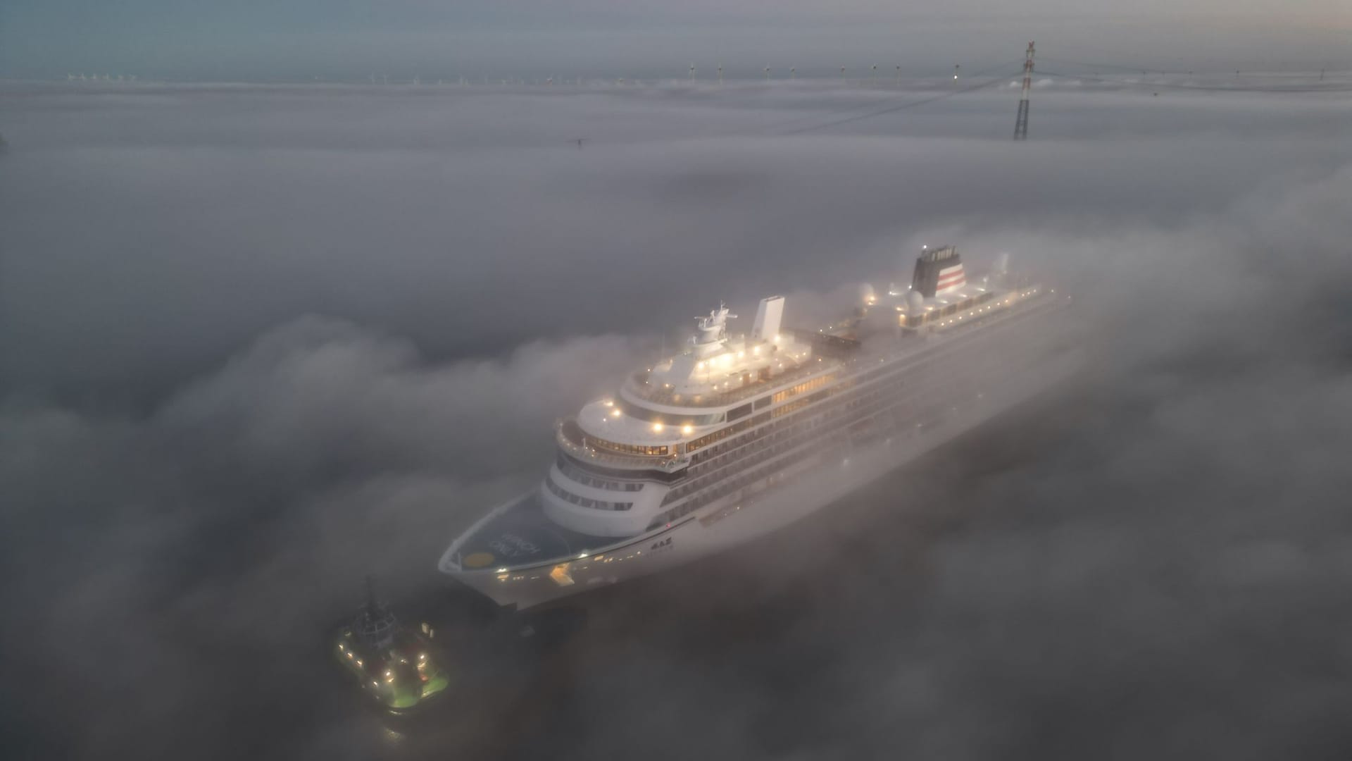 Im dichten Nebel wird das Luxus-Kreuzfahrtschiff überführt. Das Spektakel zieht viele Schaulustige an.