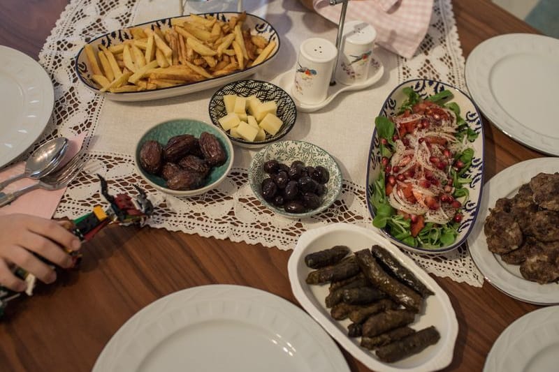 Kinder und Eltern nehmen während des heiligen Fastenmonats Ramadan ein gemeinsames Iftar-(Fastenbrechen-)Essen in ihrer Wohnung ein. Tagsüber nehmen Gläubige im Ramadan nichts zu sich, erst nach Sonnenuntergang essen und trinken sie beim Fastenbrechen - Iftar.