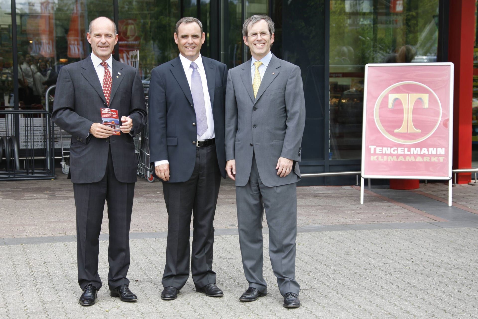 Karl-Erivan Haub (l.) mit seinen Brüdern Georg (M.) und Christian vor einem Tengelmann-Markt in Mülheim.