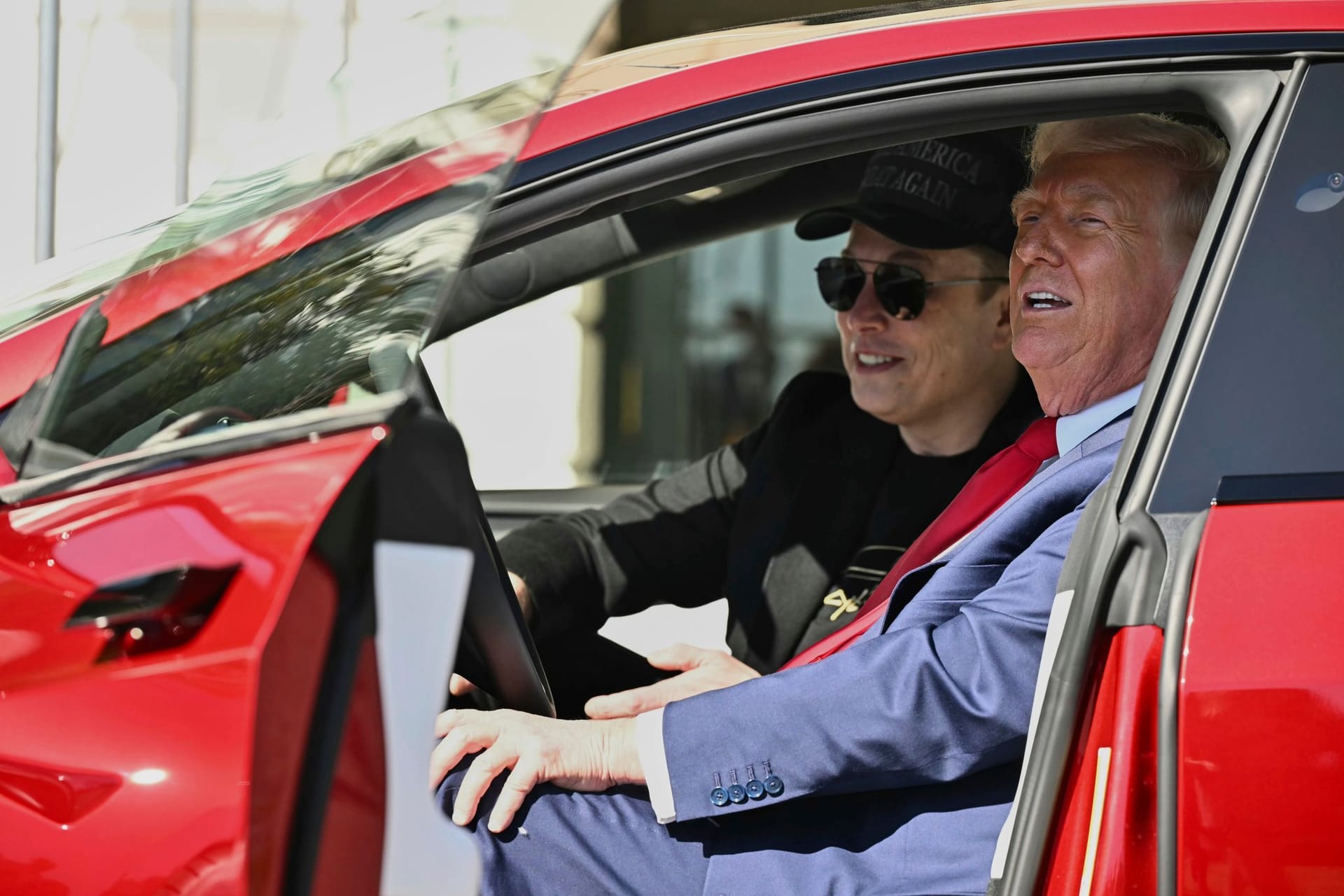 Donald Trump (r.) und Elon Musk sitzen in einem neuen Tesla. Trotz der PR-Aktion sinken die Verkaufszahlen den Elektroautobauers.