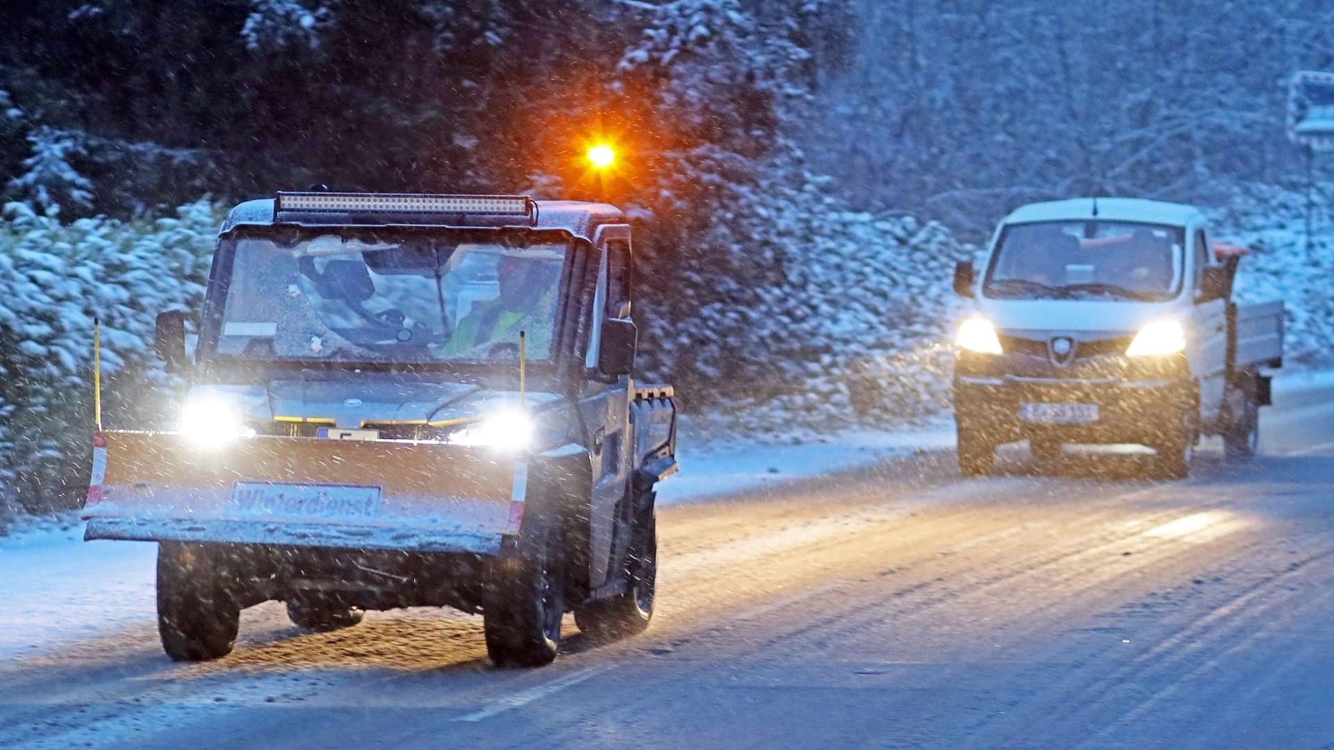 Ein Räumfahrzeug fährt über eine verschneite Straße in Nordrhein-Westfalen: In Köln und der Region stürzen die Temperaturen ab. Im Umland droht kräftiger Neuschnee.