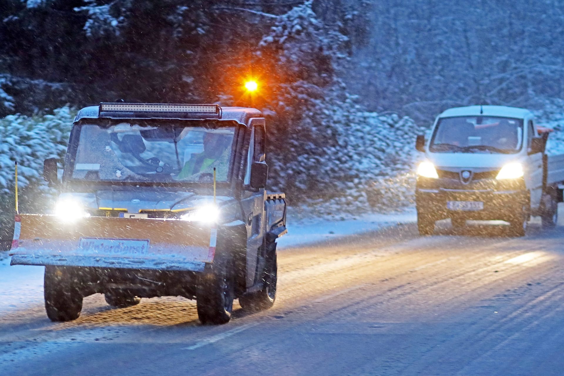 Ein Räumfahrzeug fährt über eine verschneite Straße in Nordrhein-Westfalen: In Köln und der Region stürzen die Temperaturen ab. Im Umland droht kräftiger Neuschnee.