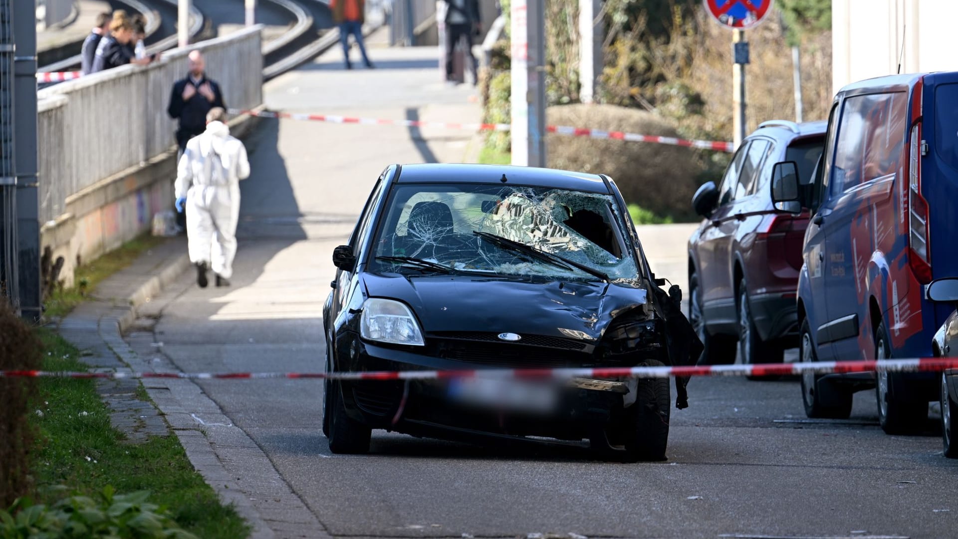 Ein beschädigtes Fahrzeug steht an einer Zufahrt zur Rheinbrücke: Der mutmaßliche Fahrer wurde festgenommen.