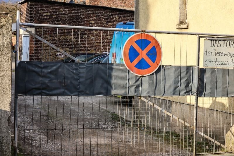 Blick in den Hinterhof, in dem der Verkäufer die Frauen angegriffen haben soll: Das Heck des blauen Eisautos ist hinter der Absperrung zu erkennen.