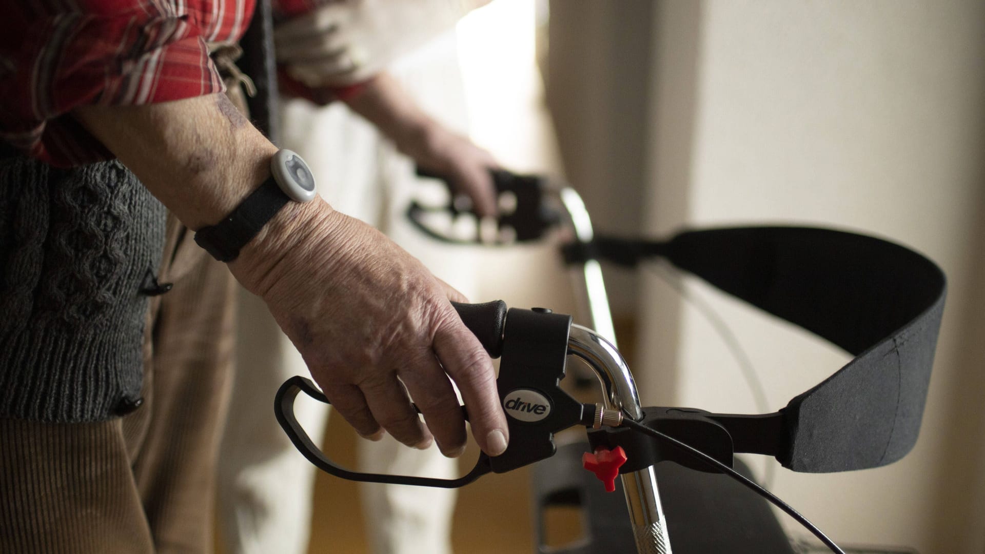 Ein Pfleger hilft einem Senior mit Rollator (Symbolbild): Die Männer sollen nicht erbrachte Leistungen abgerechnet haben.