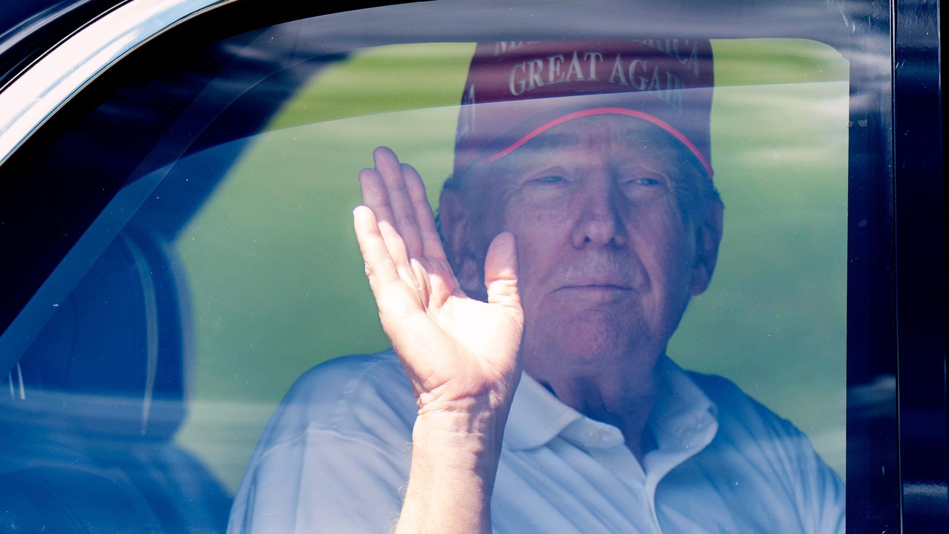 US-Präsident Donald Trump winkt aus seiner Limousine, als er den Trump International Golf Club verlässt.