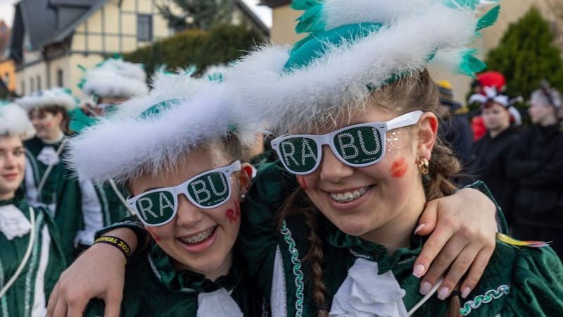 Beim Faschingsumzug in Radeburg tragen Zwei junge Frauen Sonnenbrillen, auf den "RABU" steht. Unter dem Motto der 68. Saison: „RaBuMania – Karneval der Extreme!“ lässt der Radeburger Carnevals-Clubs RCC den Umzug wieder zu einem Highlight in der fünften Jahreszeit werden.