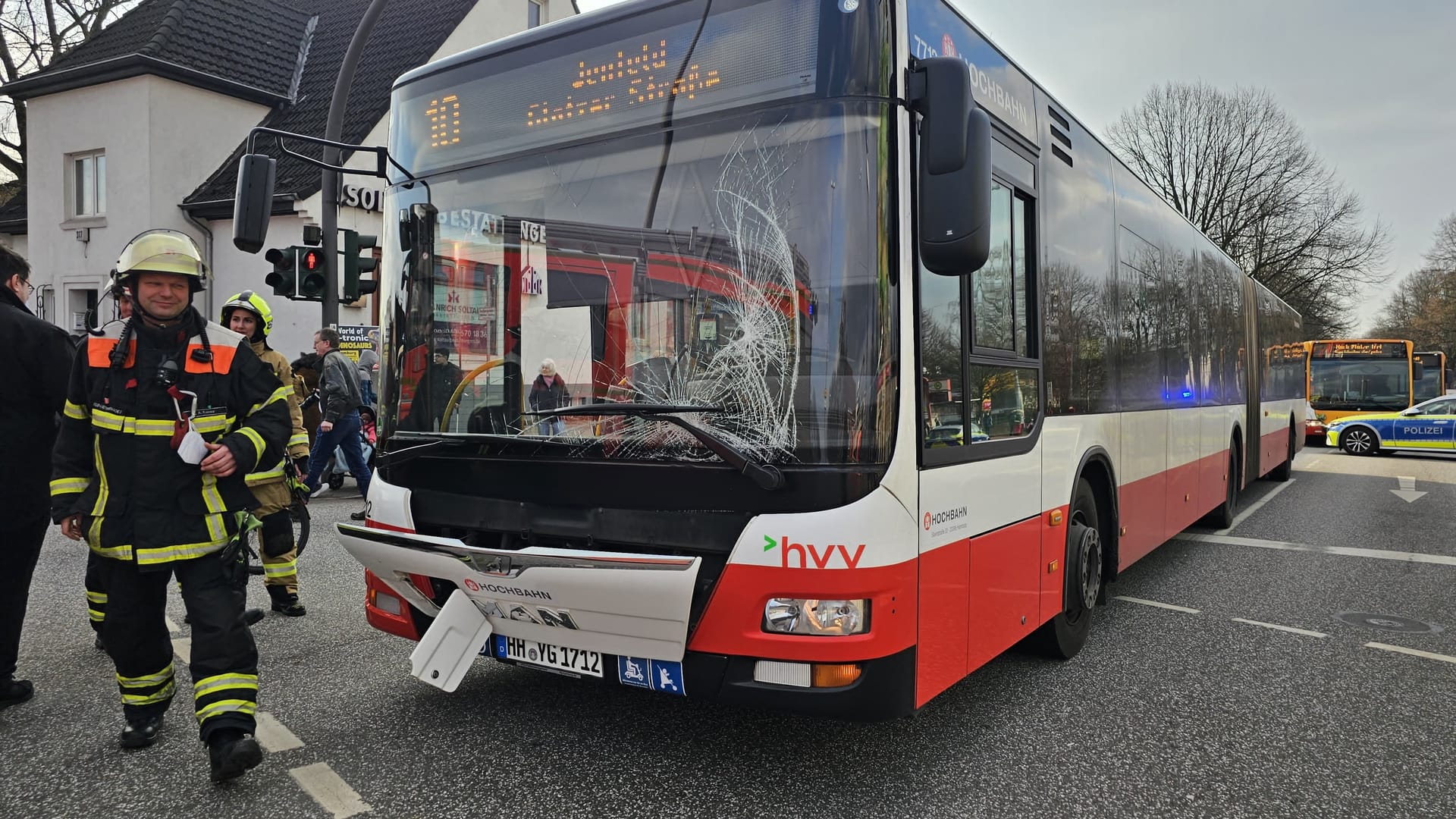 Ein Feuerwehrmann vor einem Bus der Linie 10 in Hamburg-Jenfeld: Ein durch sein Handy abgelenkter Fußgänger verursachte einen Unfall.