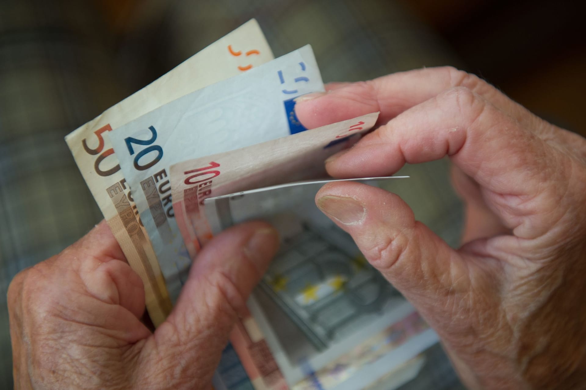 Rentner zählt Geldscheine